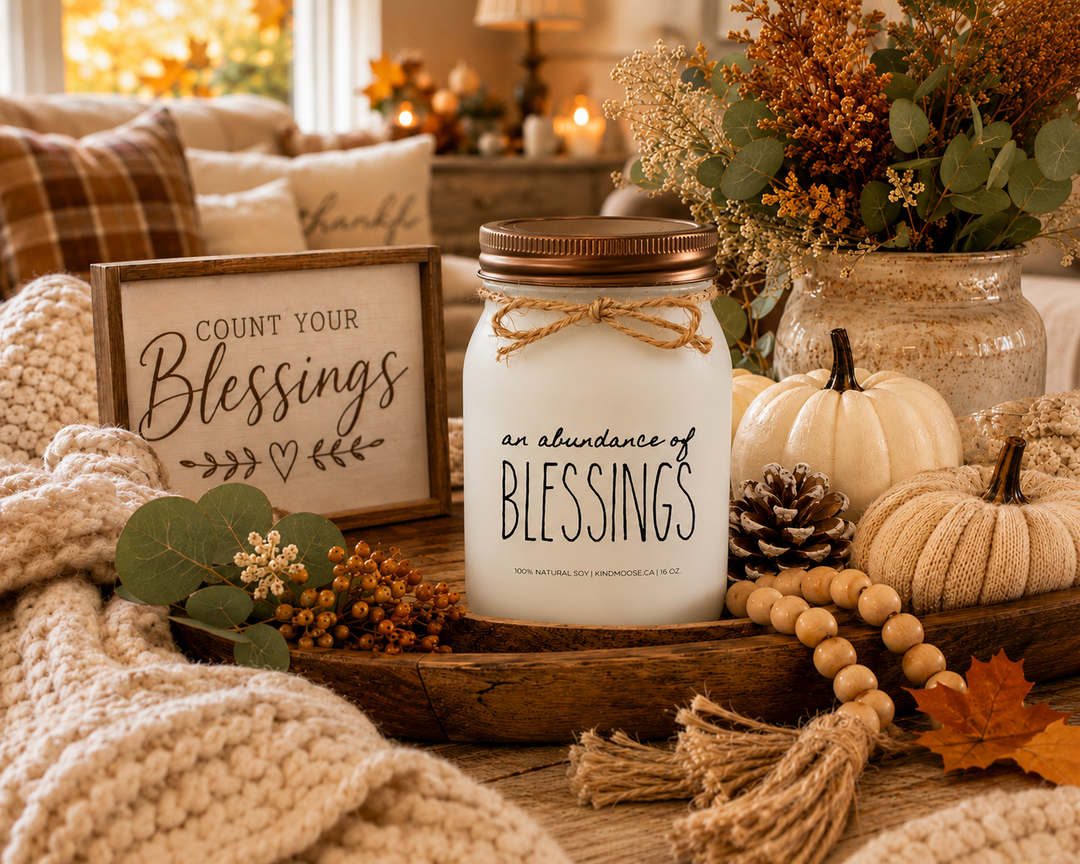 AN ABUNDANCE OF BLESSINGS soy candle with distressed bronze lid styled as a thoughtful Thanksgiving hostess gift surrounded by autumn greenery, neutral pumpkins, seasonal décor, and warm harvest accents.