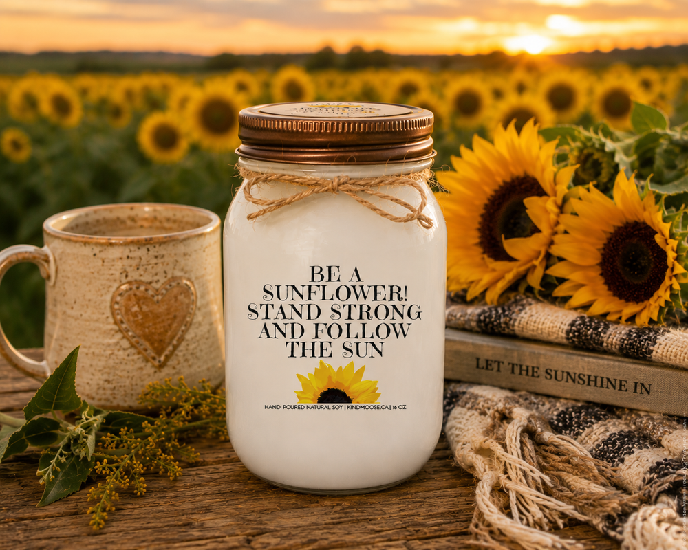 BE A SUNFLOWER! STAND STRONG AND FOLLOW THE SUN soy candle with distressed bronze lid styled in a sunflower field gathering scene with fresh blooms, countryside charm, and warm autumn sunshine.
