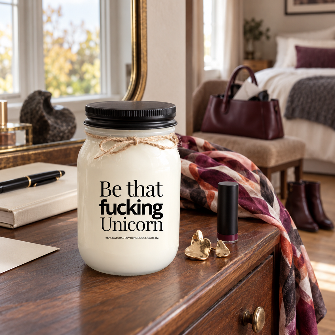 Be That Fucking Unicorn KINDMOOSE candle with black lid in a sophisticated bedroom dressing area with bold personal accessories.