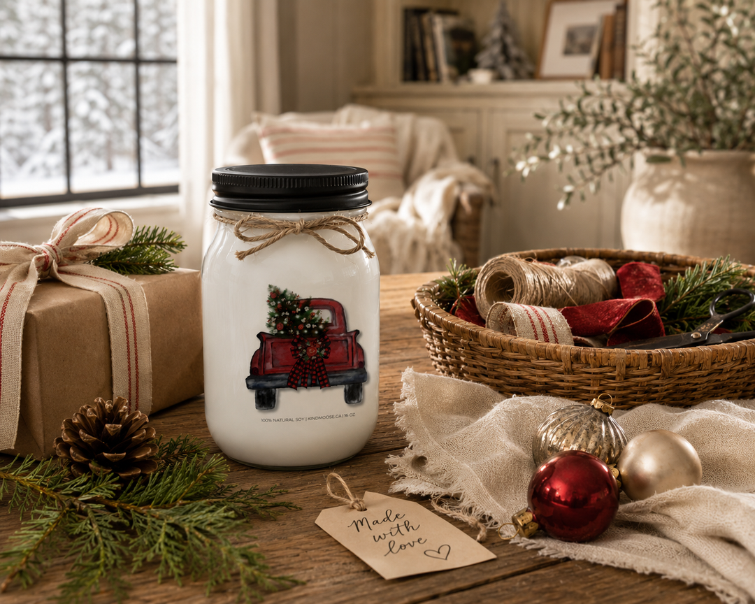 CHRISTMAS TREE TRUCK personalized Christmas candle styled as a thoughtful holiday gift on a reclaimed white oak entry console with wrapped presents, cedar branches, pinecones, velvet ribbon, brass accents, and a bright luxury farmhouse foyer.