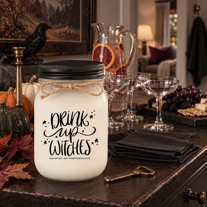 DRINK UP WITCHES 16 oz KINDMOOSE candle with black lid styled for a sophisticated Halloween girls' night in a warm home entertaining space.