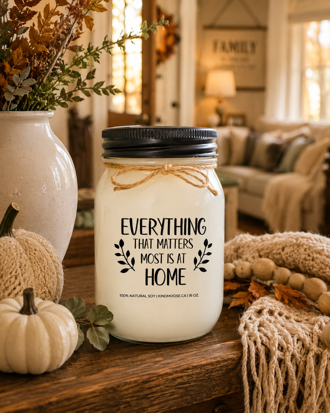 EVERYTHING THAT MATTERS MOST IS AT HOME soy candle displayed on a farmhouse entry table surrounded by neutral pumpkins, autumn greenery, woven textures, and cozy fall décor in a welcoming family home.