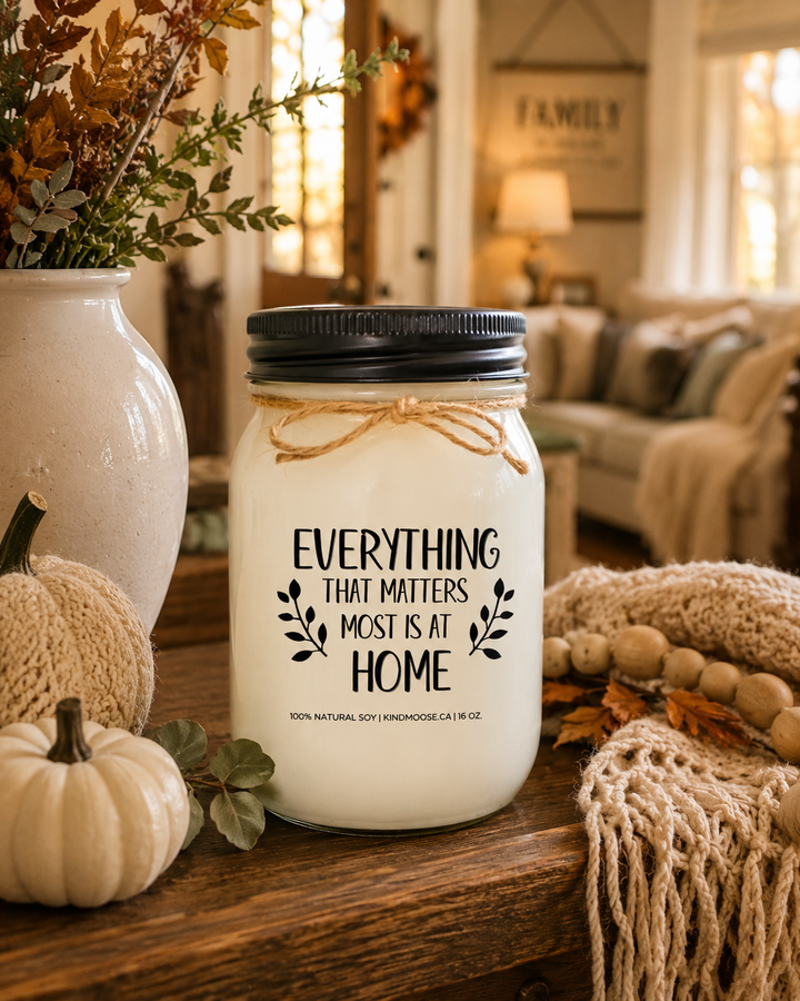 EVERYTHING THAT MATTERS MOST IS AT HOME soy candle displayed on a farmhouse entry table surrounded by neutral pumpkins, autumn greenery, woven textures, and cozy fall décor in a welcoming family home.