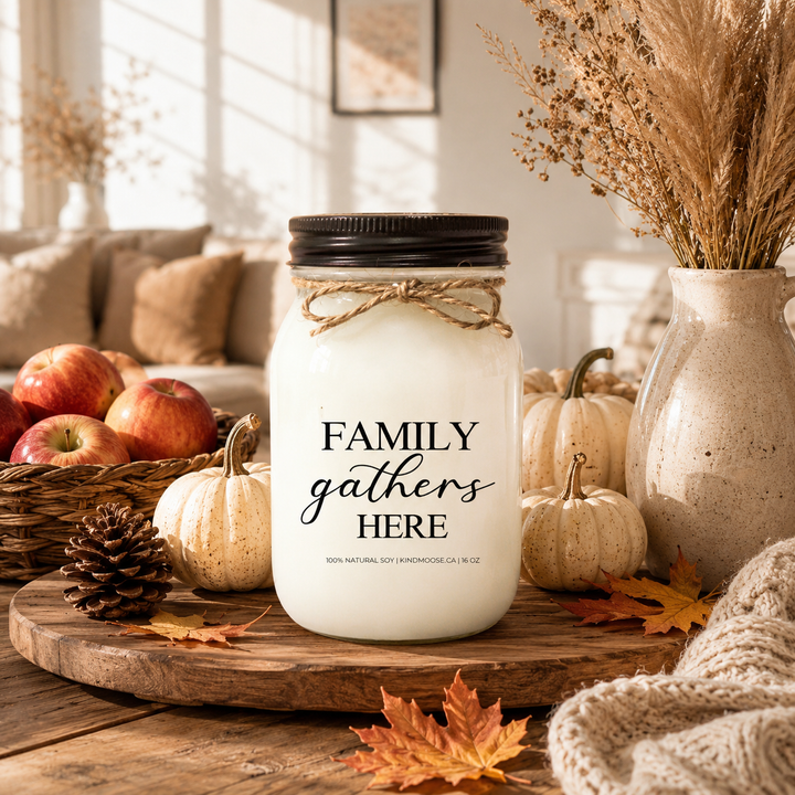 FAMILY GATHERS HERE soy candle displayed on a rustic farmhouse entry table with neutral pumpkins, autumn greenery, woven textures, and warm seasonal décor. Soft autumn sunlight fills the home, creating a welcoming atmosphere that celebrates family, comfort, and togetherness.