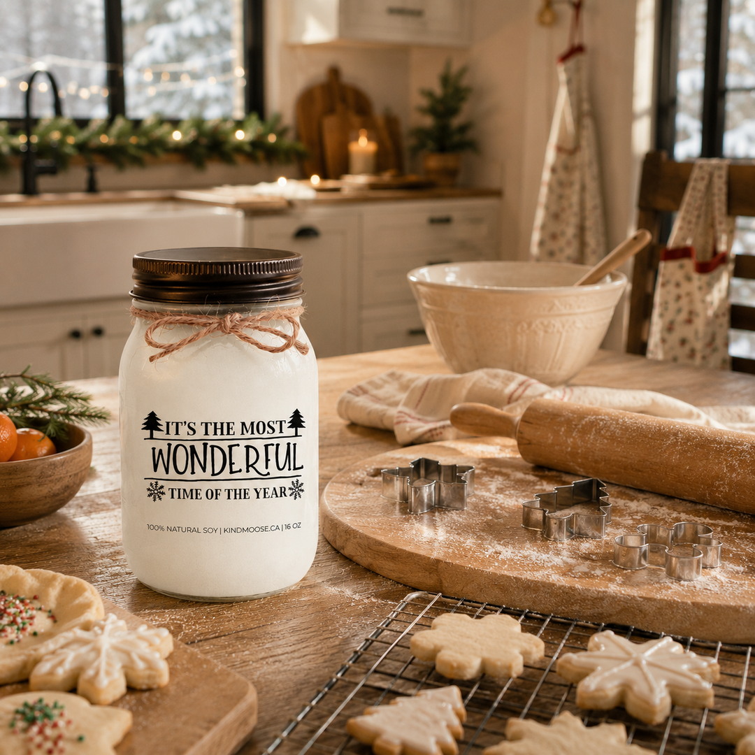 KINDMOOSE It’s the Most Wonderful Time of the Year candle on a farmhouse kitchen island during a family Christmas baking day.