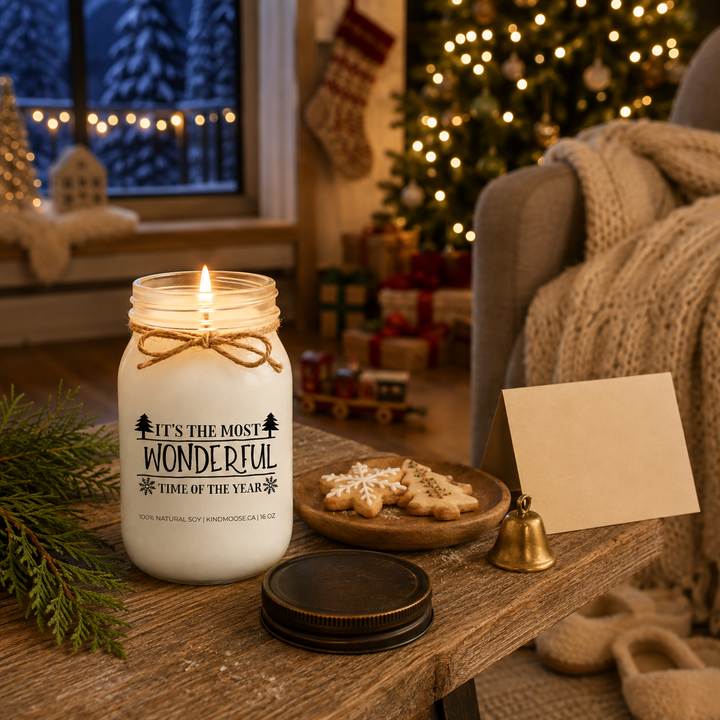 Burning KINDMOOSE It’s the Most Wonderful Time of the Year candle beside a cozy armchair on a peaceful snowy Christmas Eve.