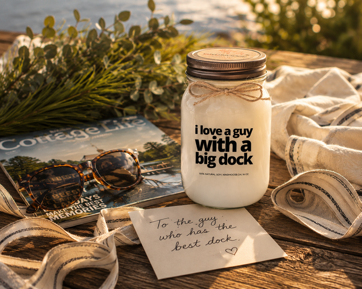 I Love A Guy With A Big Dock candle styled as a thoughtful cottage gift with handwritten note, linen ribbon, greenery, and lake house décor.