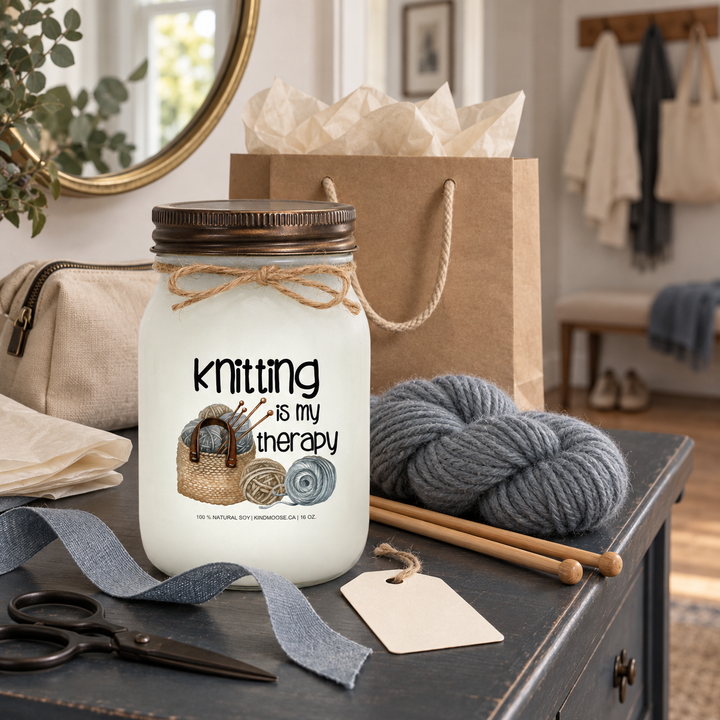 KINDMOOSE Knitting Is My Therapy candle styled with yarn, knitting needles and gift packaging as a thoughtful gift for a knitter.