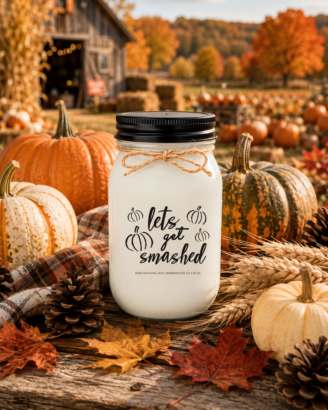 LET'S GET SMASHED soy candle displayed on a rustic farmhouse harvest table surrounded by heirloom pumpkins, colourful autumn leaves, pinecones, wheat stems, and cozy seasonal décor. Warm autumn sunlight and a countryside harvest backdrop celebrate pumpkin season, fall traditions, and the excitement of welcoming autumn.