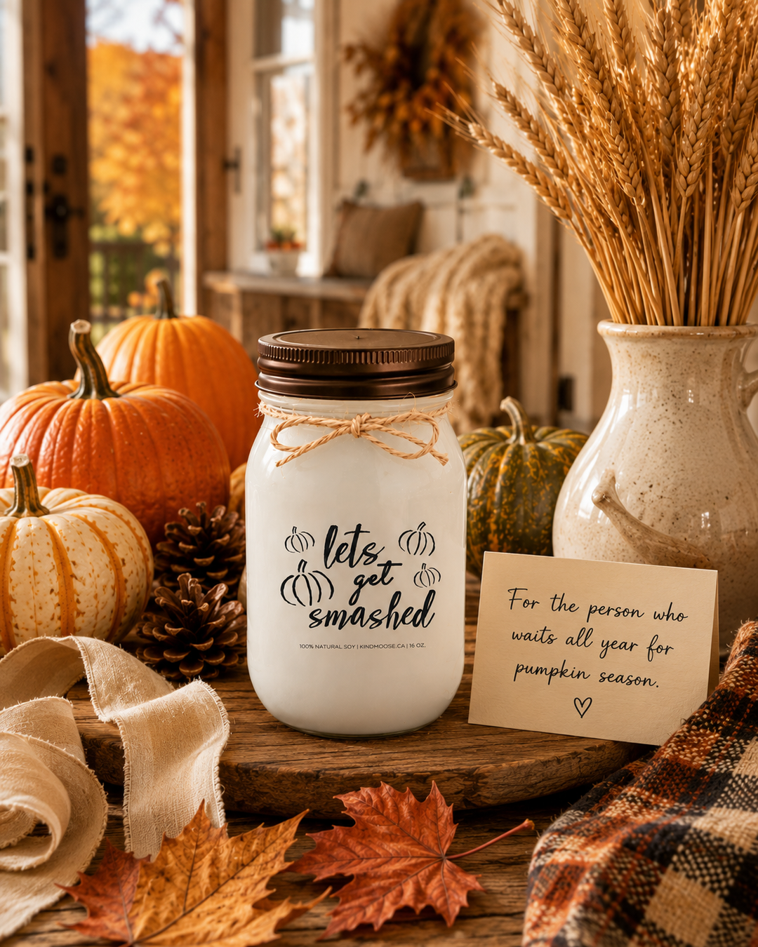 LET'S GET SMASHED soy candle with distressed bronze lid displayed as a thoughtful fall gift on a farmhouse entry table. Surrounded by heirloom pumpkins, autumn leaves, pinecones, wheat stems, linen ribbon, and a handwritten gift card, the scene celebrates pumpkin season, harvest traditions, and the excitement of autumn for devoted fall lovers.