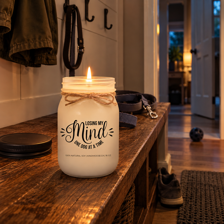 Burning LOOSING MY MIND ONE DOG AT A TIME KINDMOOSE candle in an evening mudroom with dog leashes, toy and a missing shoe.