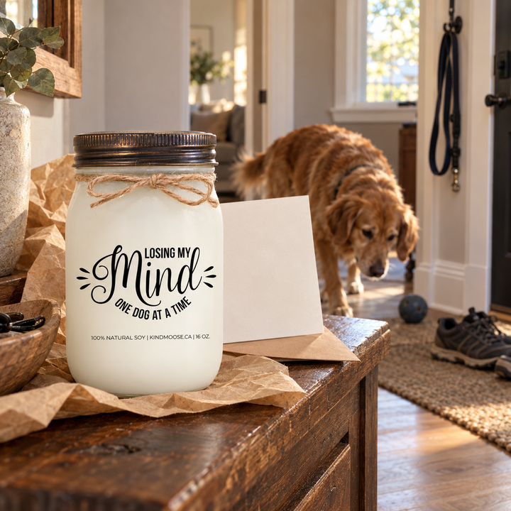 LOOSING MY MIND ONE DOG AT A TIME KINDMOOSE candle presented as a thoughtful gift in a dog-loving home with a curious dog nearby.
