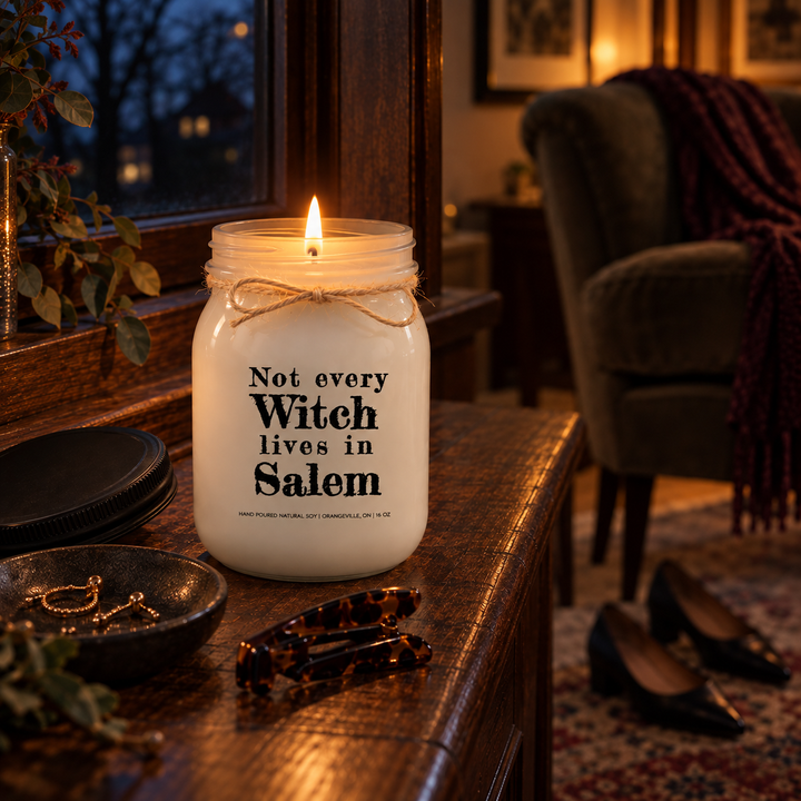 Not Every Witch Lives in Salem KINDMOOSE candle burning by a window in a quiet evening den with a single natural flame.