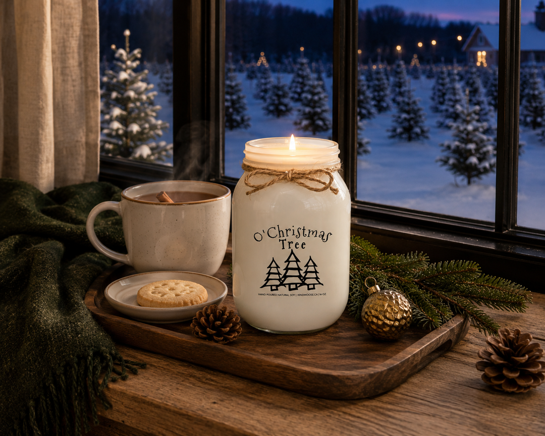 O' Christmas Tree customizable 16 oz soy candle burning on a reclaimed white oak window seat overlooking a snow-covered Christmas tree farm at blue hour, styled with a steaming mug of hot apple cider, butter shortbread cookie, Fraser fir sprigs, pinecones, and a cozy forest green wool blanket.