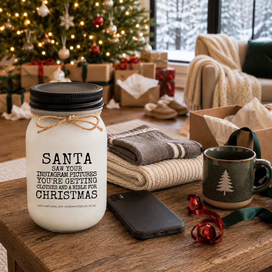 KINDMOOSE Santa Saw Your Instagram Pictures Christmas candle with black lid in a warm farmhouse Christmas morning setting with opened gifts.