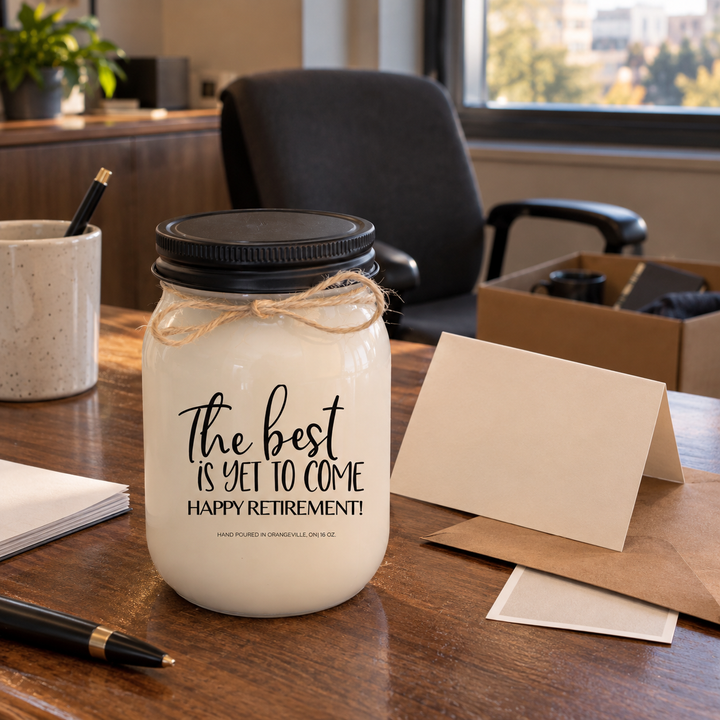 The Best Is Yet to Come Happy Retirement KINDMOOSE candle presented as a thoughtful retirement gift on a cleared workplace desk after the final workday.