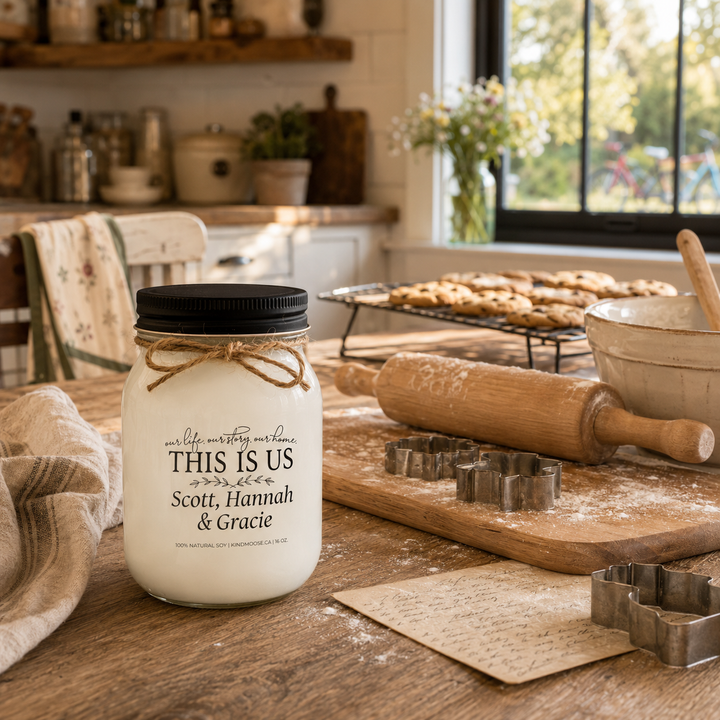 Personalized KINDMOOSE custom family candle with a black lid displayed on a farmhouse kitchen island surrounded by baking tools, cookies and family keepsakes, telling the story of generations baking together in a warm, welcoming home.