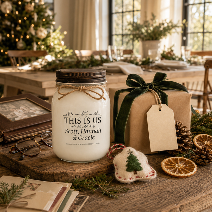 Personalized KINDMOOSE custom family candle with a distressed bronze lid presented as a thoughtful Christmas gift beside wrapped presents, family keepsakes and holiday greenery in a warm modern farmhouse dining room, celebrating love, family traditions and meaningful memories.